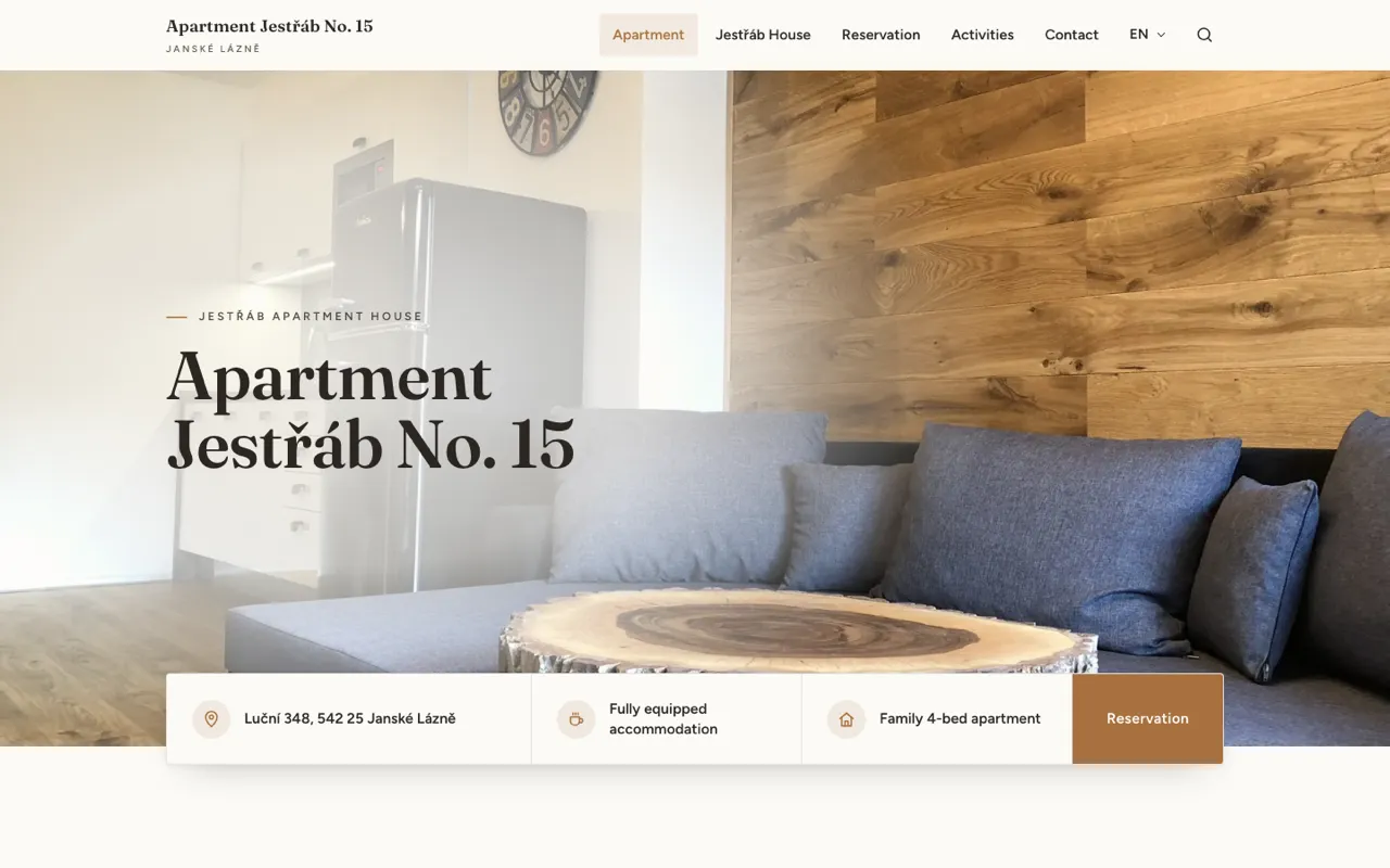 The rebuilt Apartment Jestrab homepage in English: warm oak palette, large photography, and a card of key facts overlapping the hero.